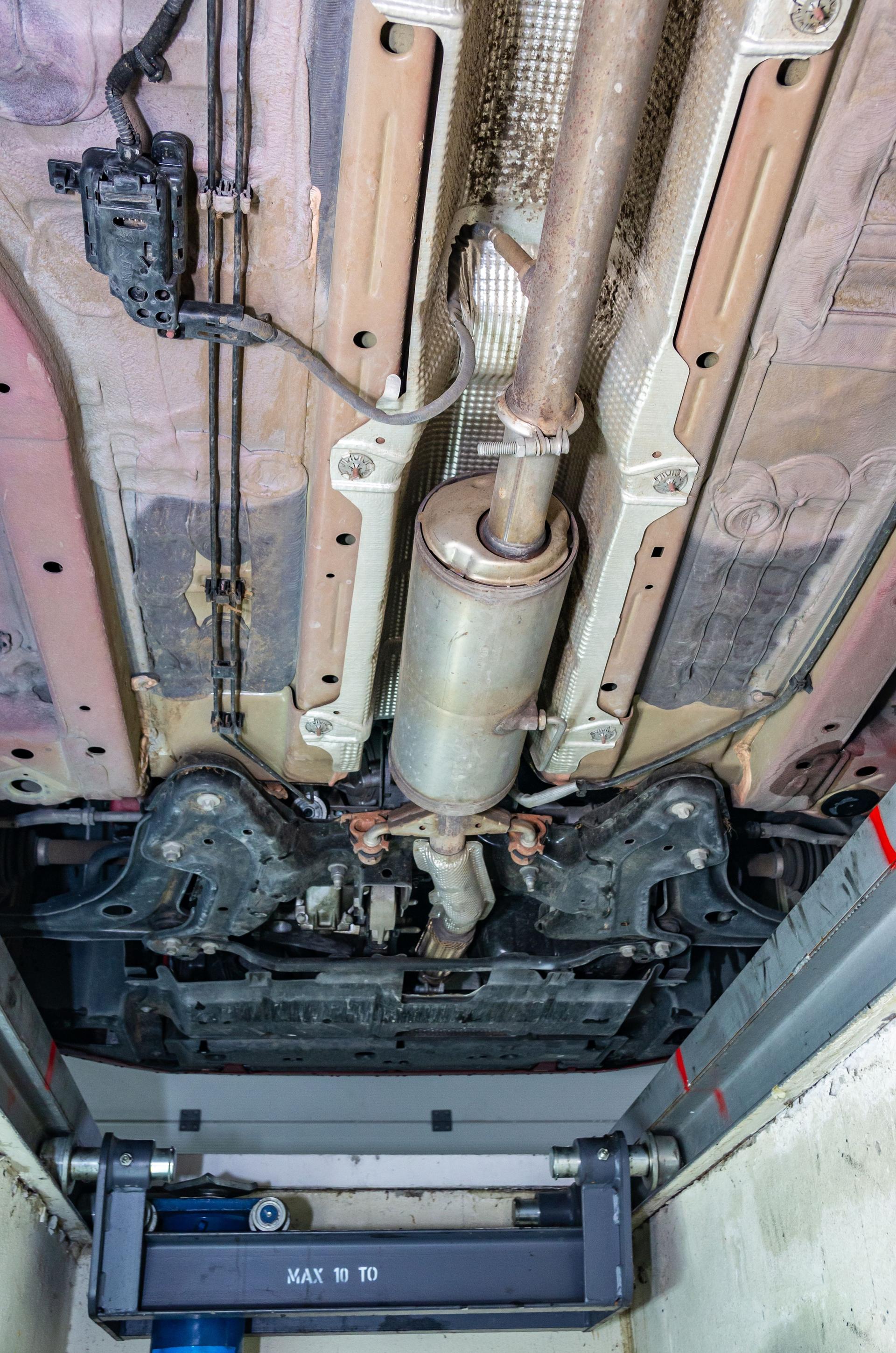 Chassis, suspension, DPF filter and exhaust of a car seen from the inspection pit